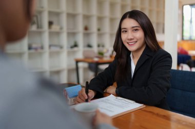 İş kadını ya da emlakçı ev almak için anlaşma imzalıyor. Banka müdürü ve emlak konsepti