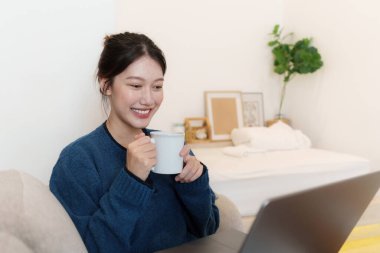 Lifestyle concept. Happy young woman using laptop at home