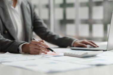 Business woman calculating the companys financial results and budget.