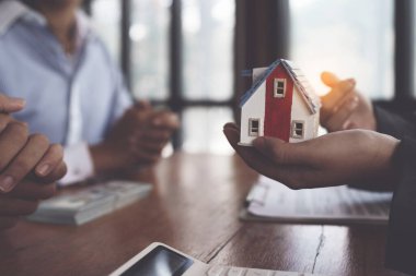 Real estate agent explain signing agreement for buying house. bank manager concept