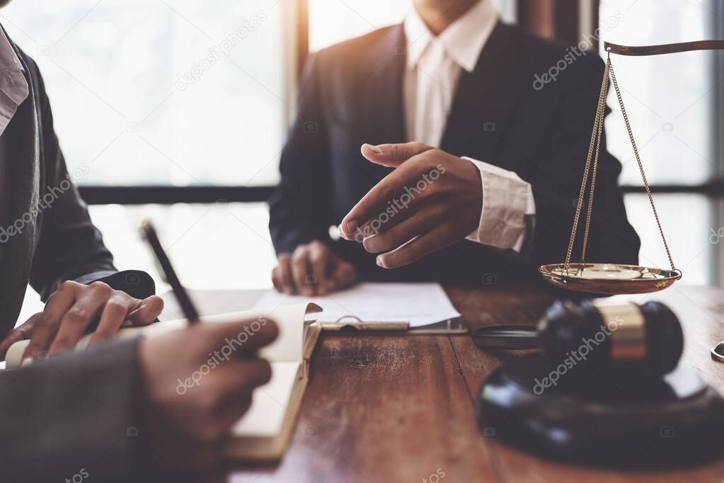 Business woman and lawyers discussing contract papers with brass scale on wooden desk in office. Law, legal services, advice, Justice concept.