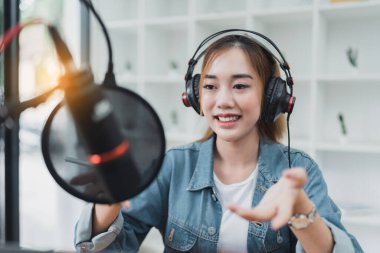 Asian podcaster making audio podcast working at home studio.
