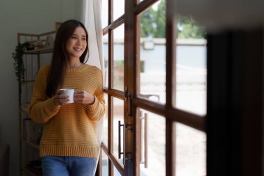 Beautiful woman relaxing and drinking coffee in morning at home.