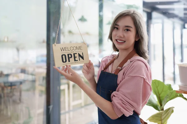 Asian Barista cafe owner smile while cafe open. SME entrepreneur seller business concept.