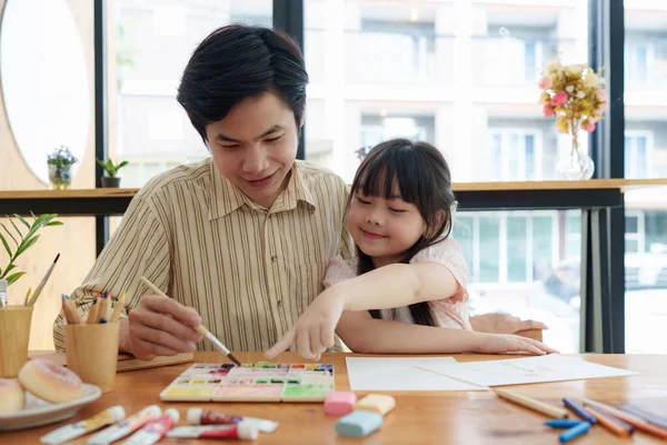 A happy kid and this father painting at home. Handmade skills training.