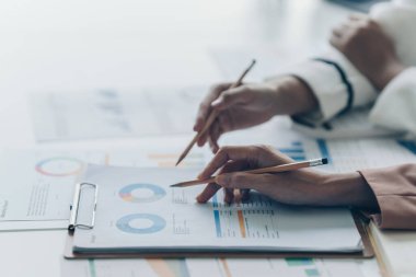 Business team support and meeting concept. Group of Investor working and pointing at financial paperwork Finance task on office desk.