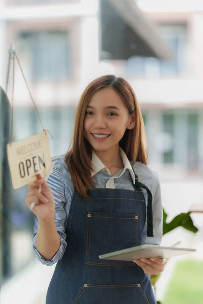 Asian Barista cafe owner smile while cafe open. SME entrepreneur seller business concept.