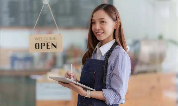 Asian Barista cafe owner smile while cafe open. SME entrepreneur seller business concept.