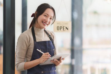 Başarılı küçük işletme sahibi güzel kız tabletle ayakta duruyor..