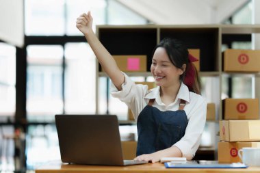 Asyalı küçük işletme sahibi ev ofisinde çalışıyor. Ticari perakende pazarı ve çevrimiçi pazarlama dağıtımı, KOBİ e-ticaret kavramı.