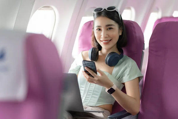 Radosna Azjatka Siedzi Samolocie Używa Telefonu Komórkowego Podczas Podróży — Zdjęcie stockowe