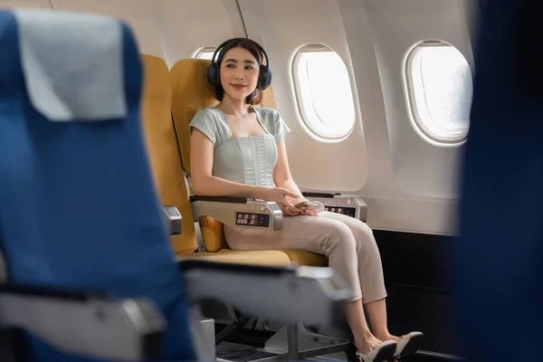 Joyful Mulher Asiática Senta Avião Ouvir Música Enquanto Vai Viajar — Fotografia de Stock