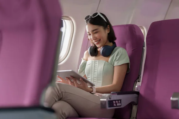 Gioioso Asiatico Donna Siede Aeroplano Utilizzando Tablet Mentre Andare Viaggiare — Foto Stock
