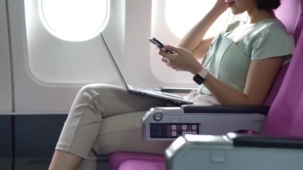 Glädjande Asiatisk Kvinna Sitter Flygplanet Och Använder Mobiltelefon När Reser — Stockvideo