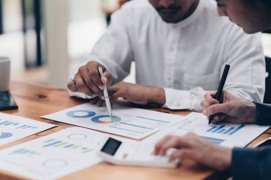 İki Asyalı fon yöneticisi yeni iş projesi finans yatırım kavramını araştırıyor.