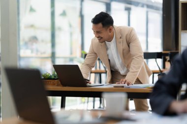 Asyalı İşadamı gülümsüyor ve teknik fiyat grafiği ve göstergesini analiz etmeye çalışıyor. finans kavramı.