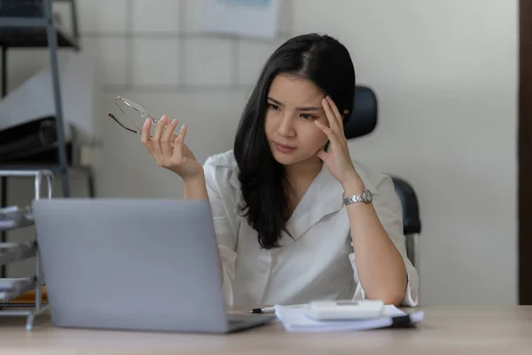 Stressed asian businesswoman with paperwork in the office. burnout syndrome or deadline project concept.