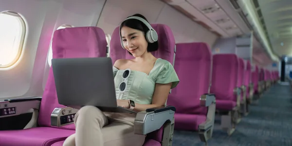 Joyful Mulher Asiática Senta Avião Usando Laptop Ouvir Música Enquanto — Fotografia de Stock
