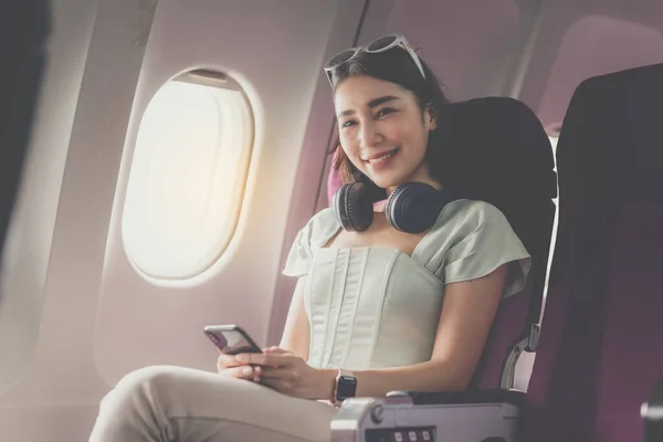 Gioioso Asiatico Donna Siede Aeroplano Utilizzando Cellulare Mentre Andare Viaggiare — Foto Stock