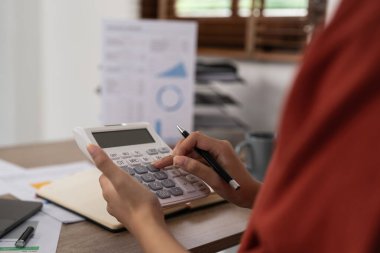 Finans sonuçlarını hesaplamak için hesap makinesi kullanan bir iş kadını. ev kavramından çalışma.