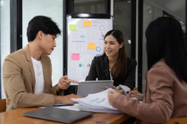 İş büyümesi, planlama ve strateji kavramı. İş adamları grubu, artan sanal istatistik hologramıyla dijital tablet kullanıyor.