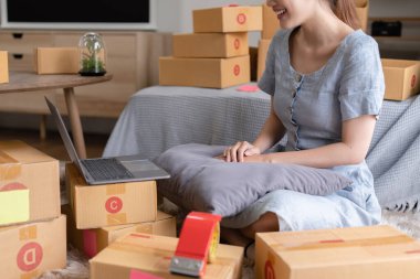 Asyalı küçük işletme sahibi ev ofisinde çalışıyor. Ticari perakende pazarı ve çevrimiçi pazarlama dağıtımı, KOBİ e-ticaret kavramı.