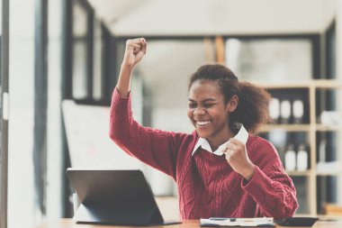 Sayısal tablete baktığında heyecanlanan mutlu Afro-Amerikan kadın..
