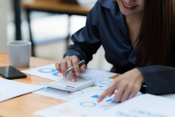 businesswoman using calculator and laptop for do math finance on wooden desk in office and business working background, tax, accounting, statistics and analytic research concept.