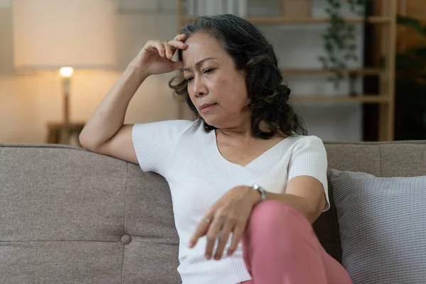 Depressed Elderly Asian woman sitting alone at home. Retired woman concept