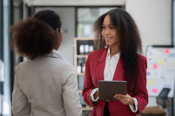 Smiling young African American businesswoman working with partner at office. finance concept.