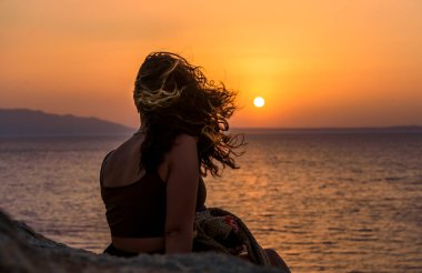 Eski şehir Knidos 'ta gün batımını izleyen bir kadın.
