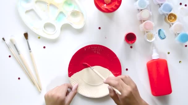The child glues the parts Santa made from paper plate. Handmade. Project of childrens creativity, handicrafts, crafts for kids. — Stock Video