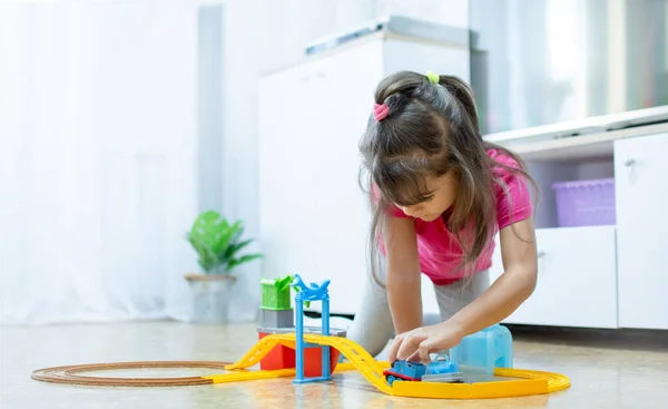 Babyspiel. Kleines schlaues kaukasisches Kind spielt bunte Spielzeugeisenbahn und trainiert für frühe Entwicklung. — Stockfoto