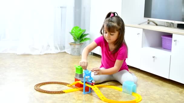 Babyspiel. Kleines schlaues kaukasisches Kind spielt bunte Spielzeugeisenbahn und trainiert für frühe Entwicklung. — Stockvideo