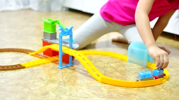 Babyspiel. Kleines schlaues kaukasisches Kind spielt bunte Spielzeugeisenbahn und trainiert für frühe Entwicklung. — Stockvideo