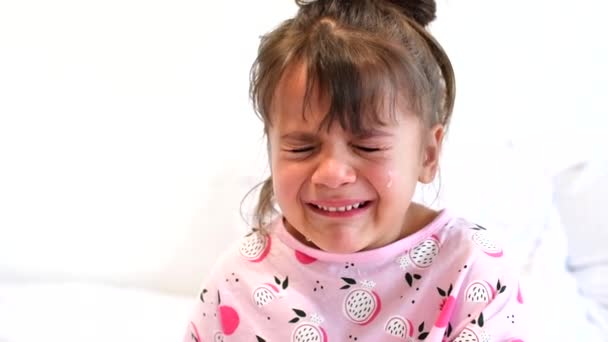 Βίντεο πορτρέτο του μικρού κοριτσιού που κλαίει με το στόμα ορθάνοιχτο και δάκρυα κάτω από το πρόσωπό της. Απομονωμένο σε λευκό φόντο. Έννοια της παιδικής ηλικίας. — Αρχείο Βίντεο
