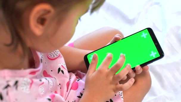 Lány használ Phone okostelefon megtekintése zöld képernyő telefonon sajtó böngészés chroma kulcs online gépelés szöveg olvasása szociális média közeli kezek — Stock videók