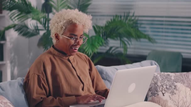 Mujer joven africana leer gran oferta comercial en el ordenador portátil se siente emocionado — Vídeos de Stock