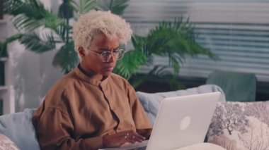 Laptop kullanan üzgün Afrikalı kadın bilgisayar sorunu yüzünden kızgın.