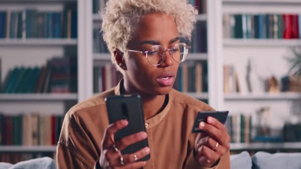 Africano americano senhora cliente segurar telefone celular cartão de crédito fazer compras on-line — Vídeo de Stock