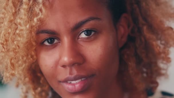 Extreme close-up glimlachen aantrekkelijk Afro Amerikaanse vrouw gezicht kijken naar camera. — Stockvideo