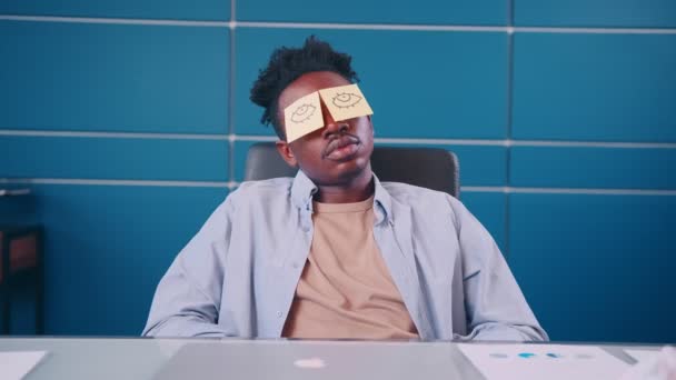 Vtipný vyčerpaný muž spí na pracovišti stažené oči na lepkavé poznámky na tváři — Stock video