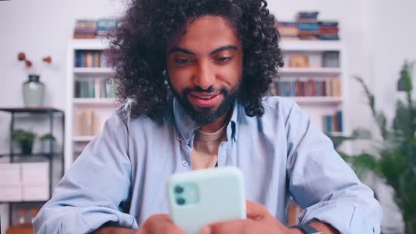 Senyum pria Timur Tengah memegang ponsel pintar menggunakan aplikasi hiburan bisnis — Stok Video