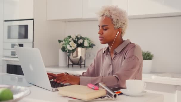 Мечтательная молодая афроамериканка смотрит вдаль, отвлекаясь от работы с ноутбуком — стоковое видео