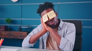 İş masasında dizüstü bilgisayarla oturan Afro-Amerikan erkek.