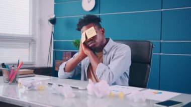 Komik tembel ofis çalışanı iş yerinde kestiriyor. Gözleri yapışkan notlarla kaplıyor.