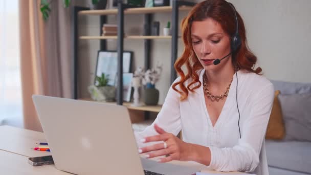 Mulher caucasiana com fone de ouvido trabalhando no serviço de suporte ao usuário do call center — Vídeo de Stock