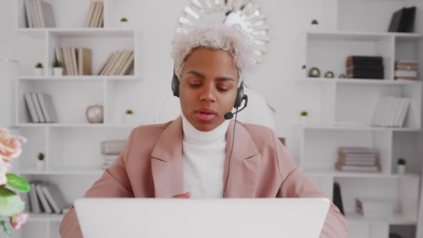 Mosolygó latin nő irodai dolgozó visel headset konferencia hívás laptop — Stock videók