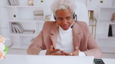 Gülümseyen Afro-Amerikan kadın kulaklık takıyor. İnternet üzerinden konuşuyor.