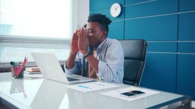 Dindar Afrikalı Amerikalı iş adamı ofis masasında el ele dua ediyor.